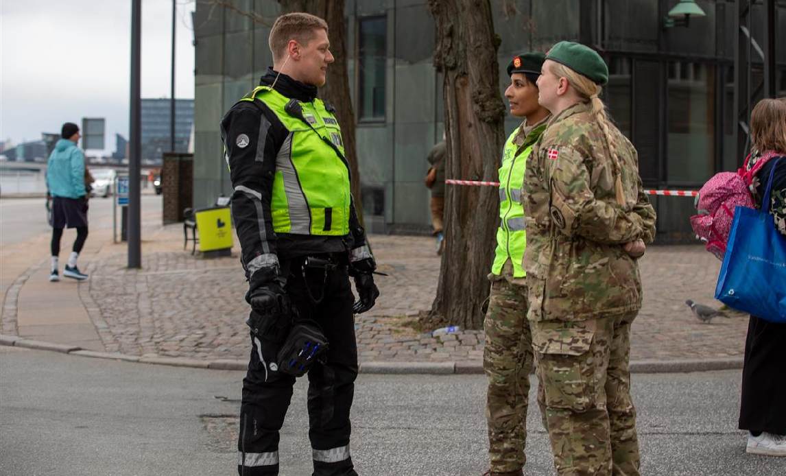 2 kvindelige Hjemmeværnssoldater taler med politibetjent.