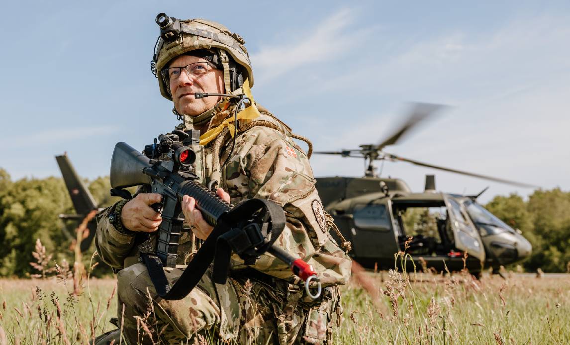 Flyverhjemmeværnssoldat på øvelsen Sort Grav foran en helikopter