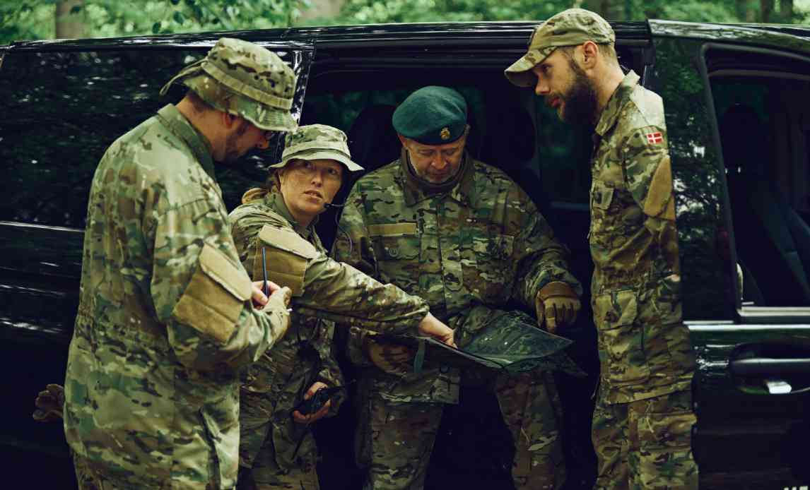 En gruppe frivillige hjemmeværnssoldater kigger på et kort ved en øvelse