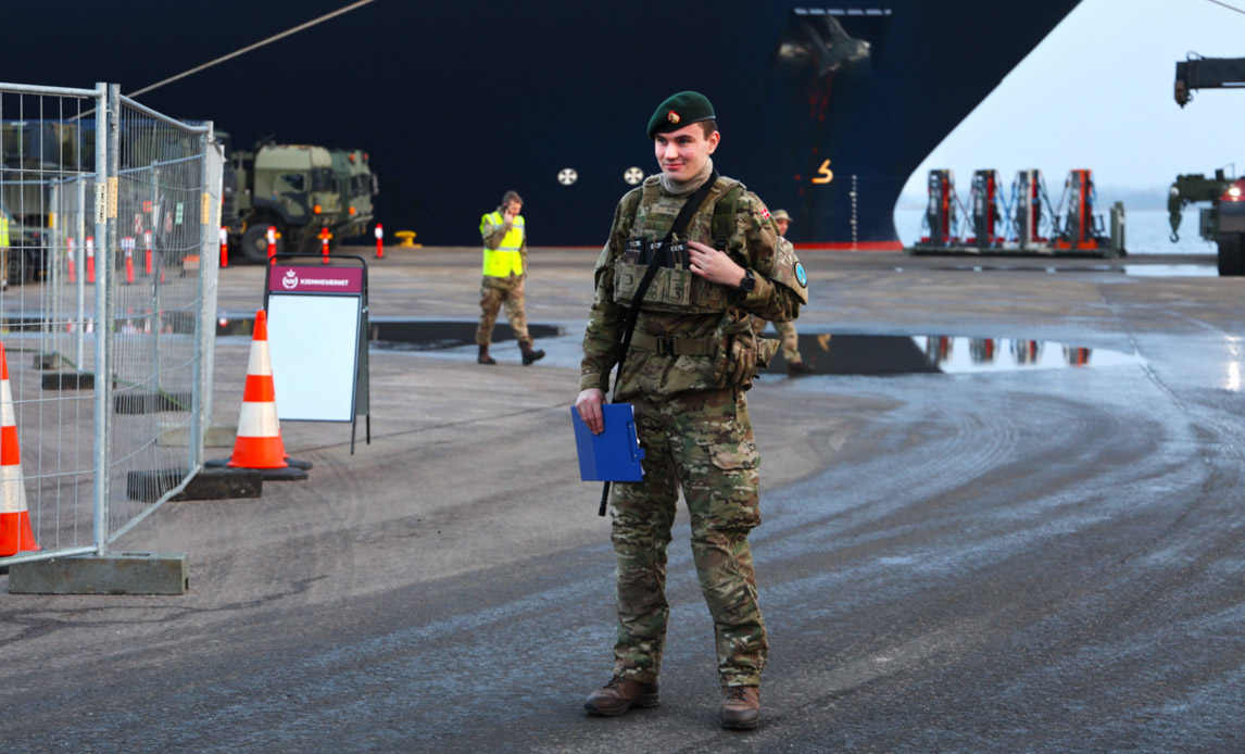 Hjemmeværnssoldat står på havnen og bevogter dansk materiel, der er kommet hjem fra udstationering i Letland.