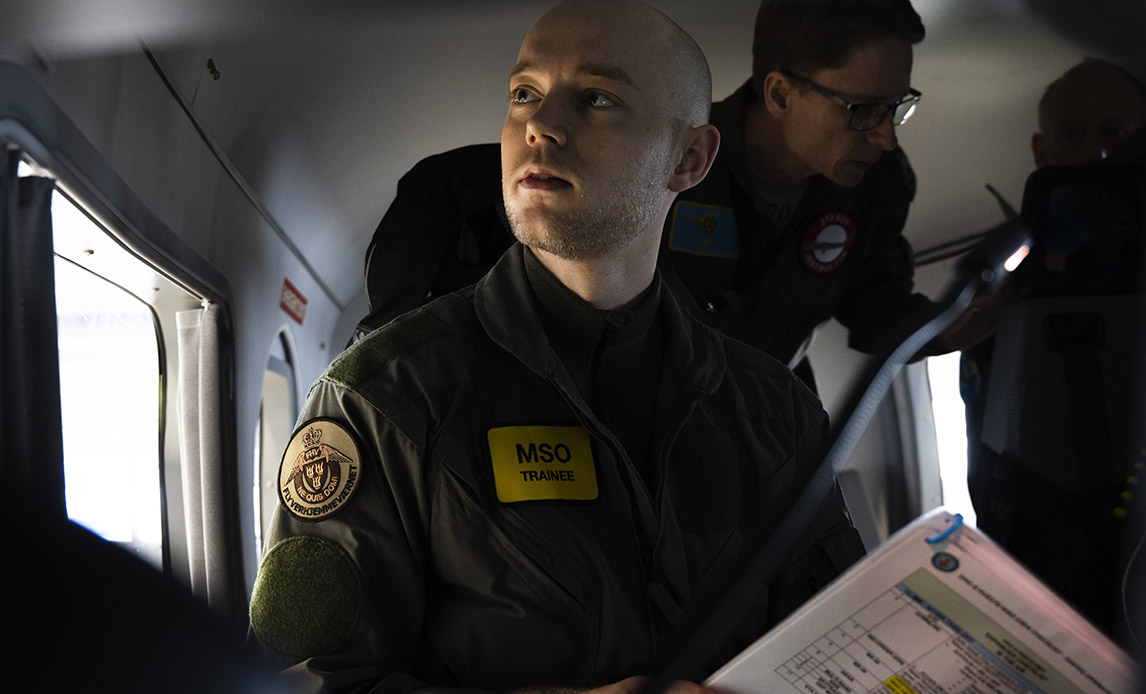 Den frivillig med flynavnet CAM sidder ved sin plads bag konsol og skærm i Twin Otteren.