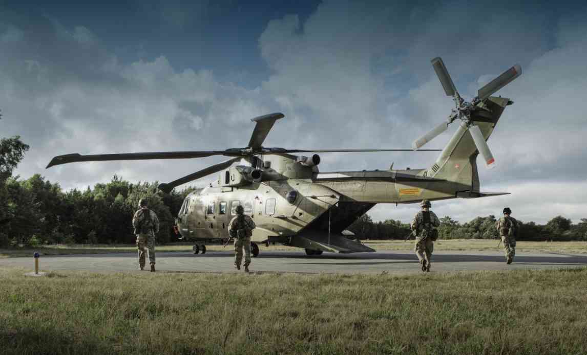 Flyverhjemmeværnssoldater står og bevogter helikopter.