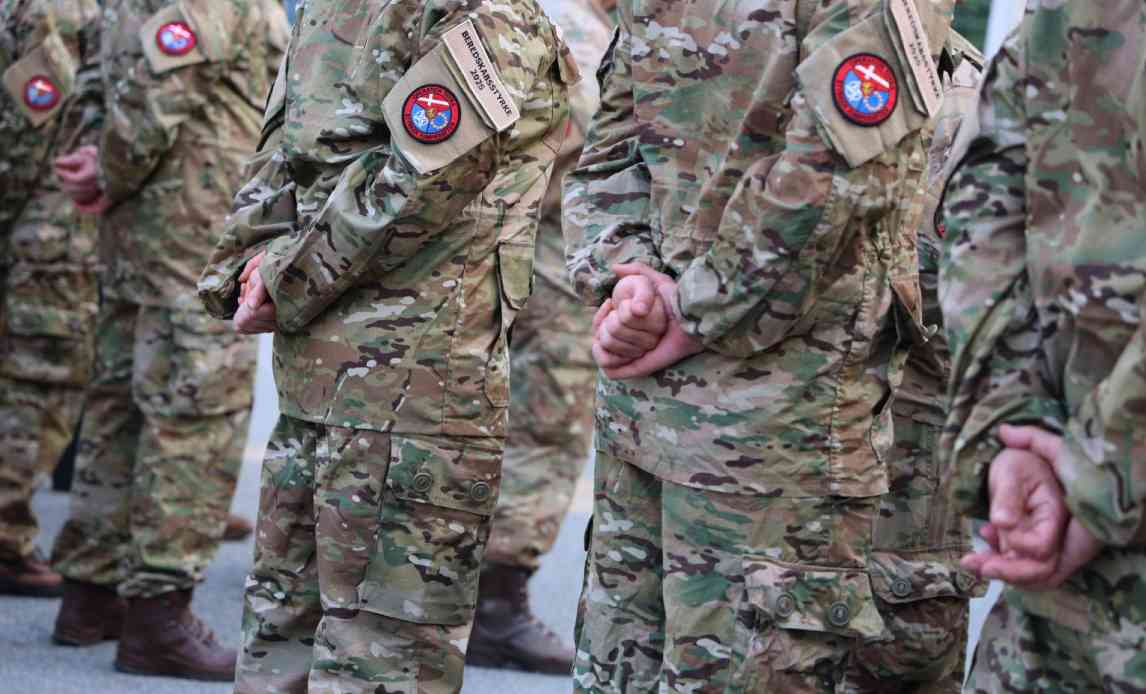 Hærhjemmeværnssoldater står med hænderne bag sig.