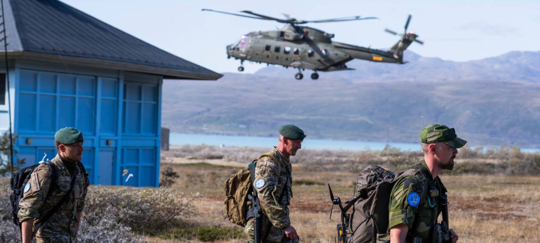 Tre soldater og en helikopter under øvelse på Grønland i 2026