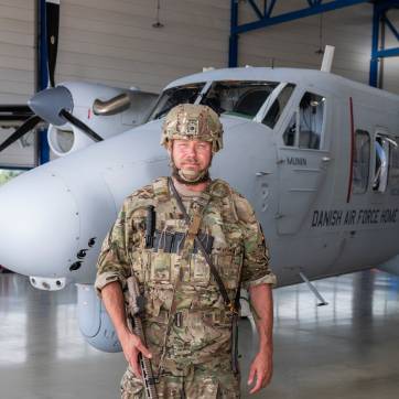 Frivillig fra Flyverhjemmeværnet står foran en af Hjemmeværnets Twin Otter fly