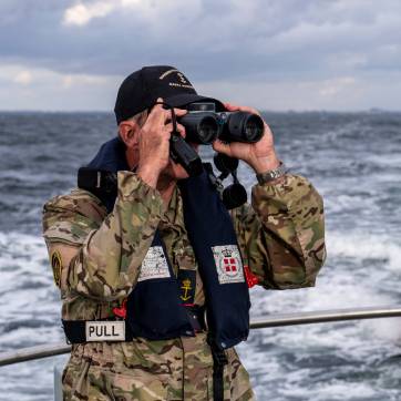 Frivillig fra Marinehjemmeværnet står og holder udkig.